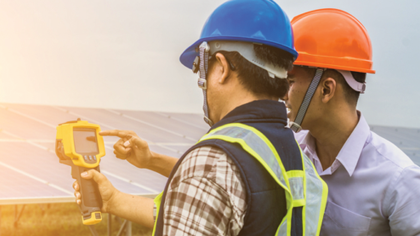 Workers taking readings from device