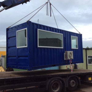 A converted shipping container in to an office loading on to a lorry