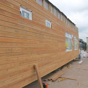 A building being covered in timber cladding
