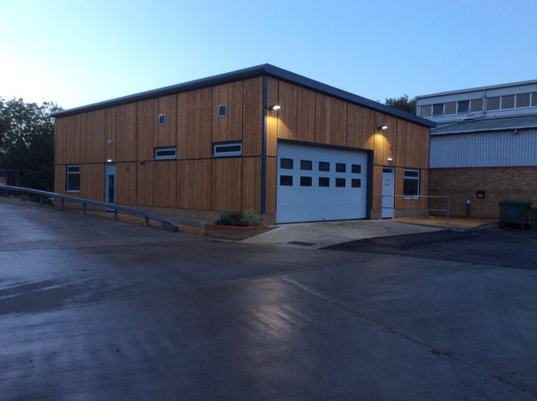 Exterior of a modular office and workshop with large doorway.